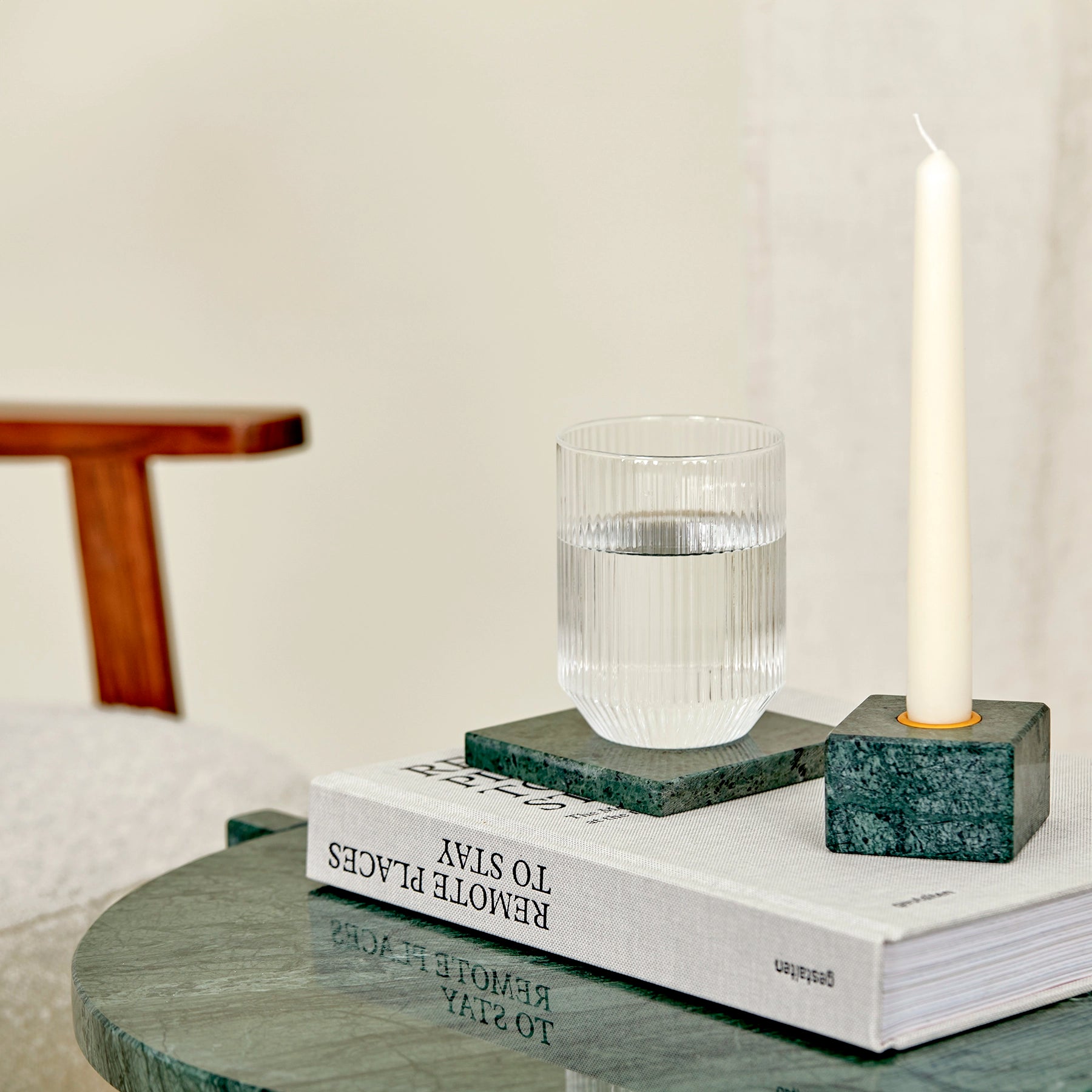A close-up of a verde guatemala marble side table and accessories.