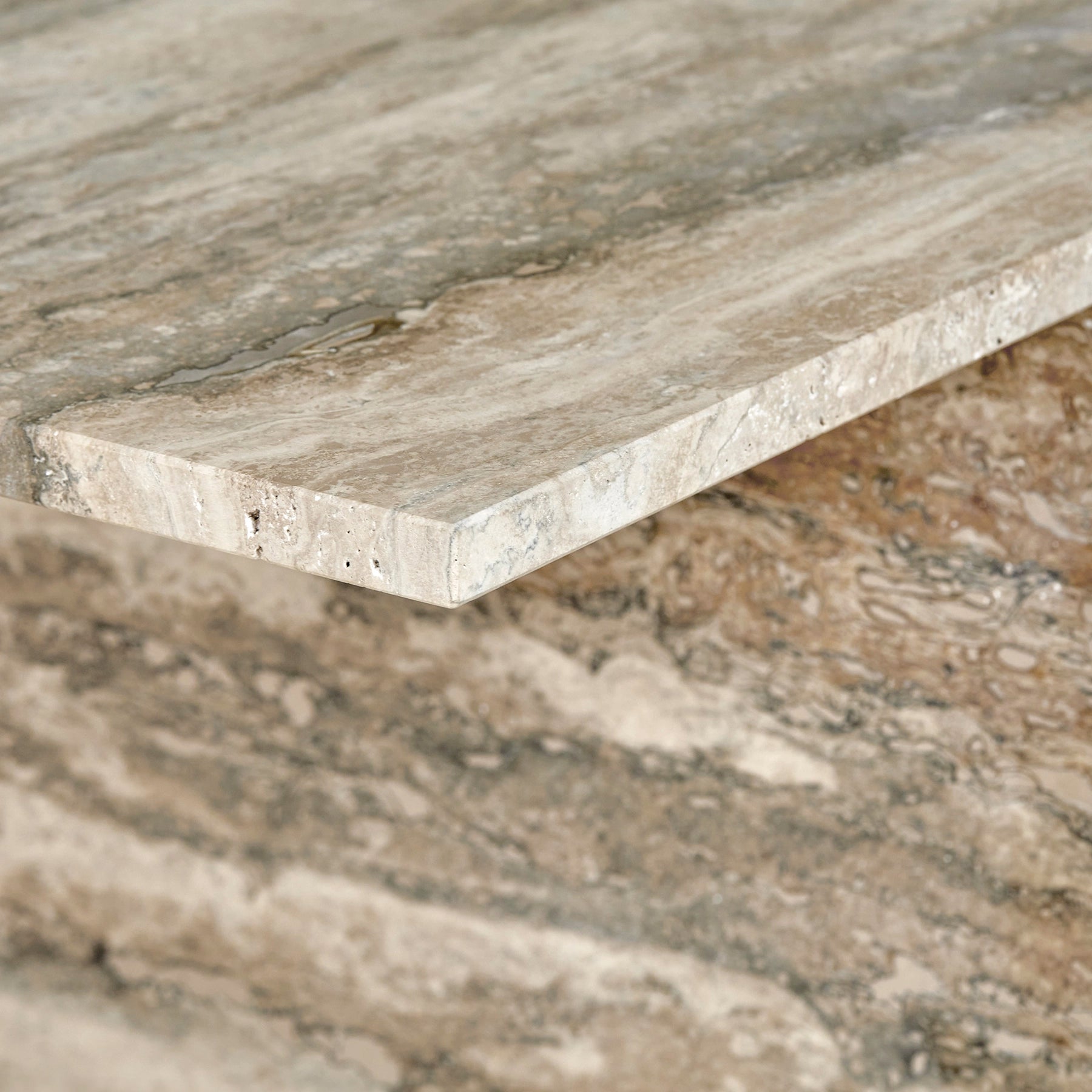 A close-up detail of an Elba side table made from travertine marble.