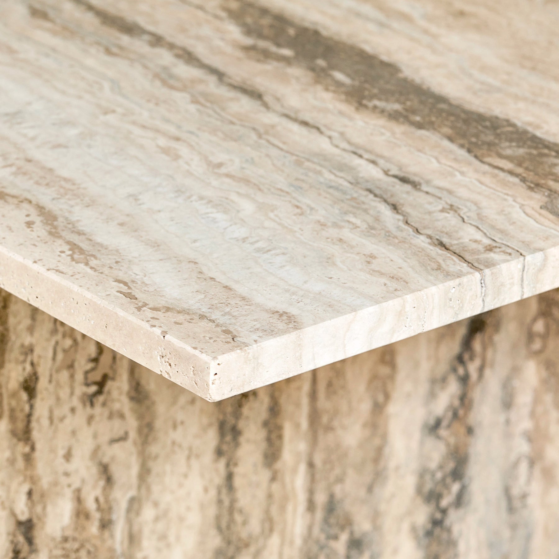 A close-up detail of an Elba side table made from travertine marble.