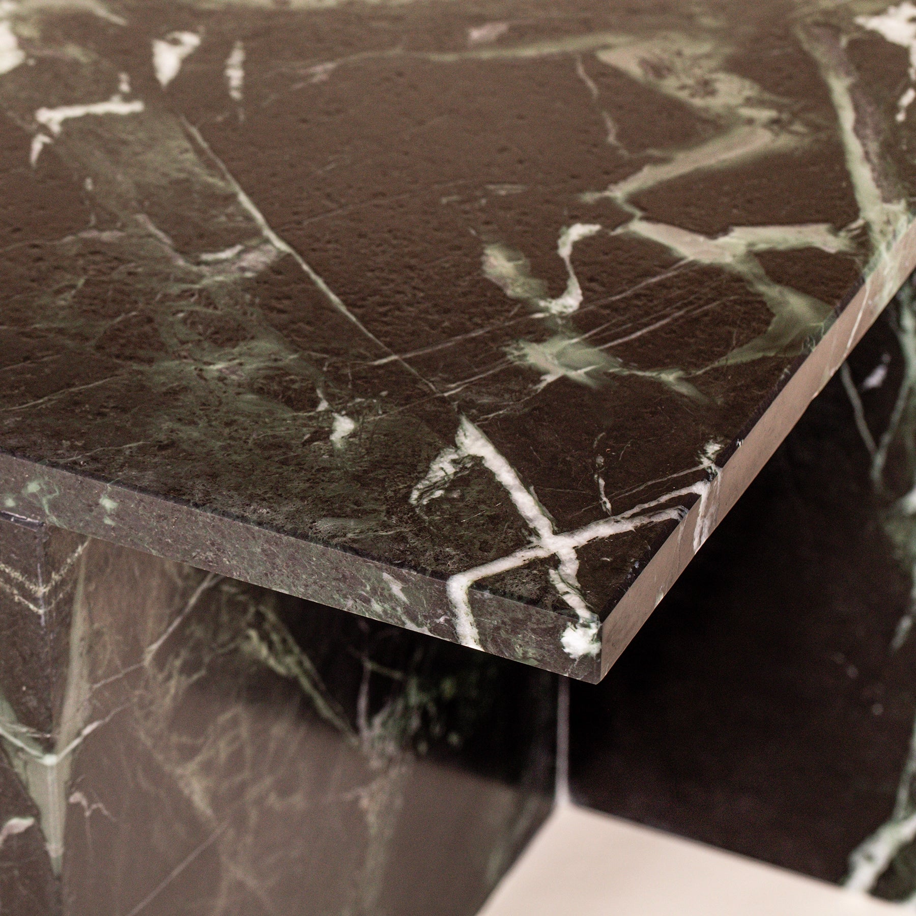 A close-up Florence - a modern side table made from Varias Green marble.