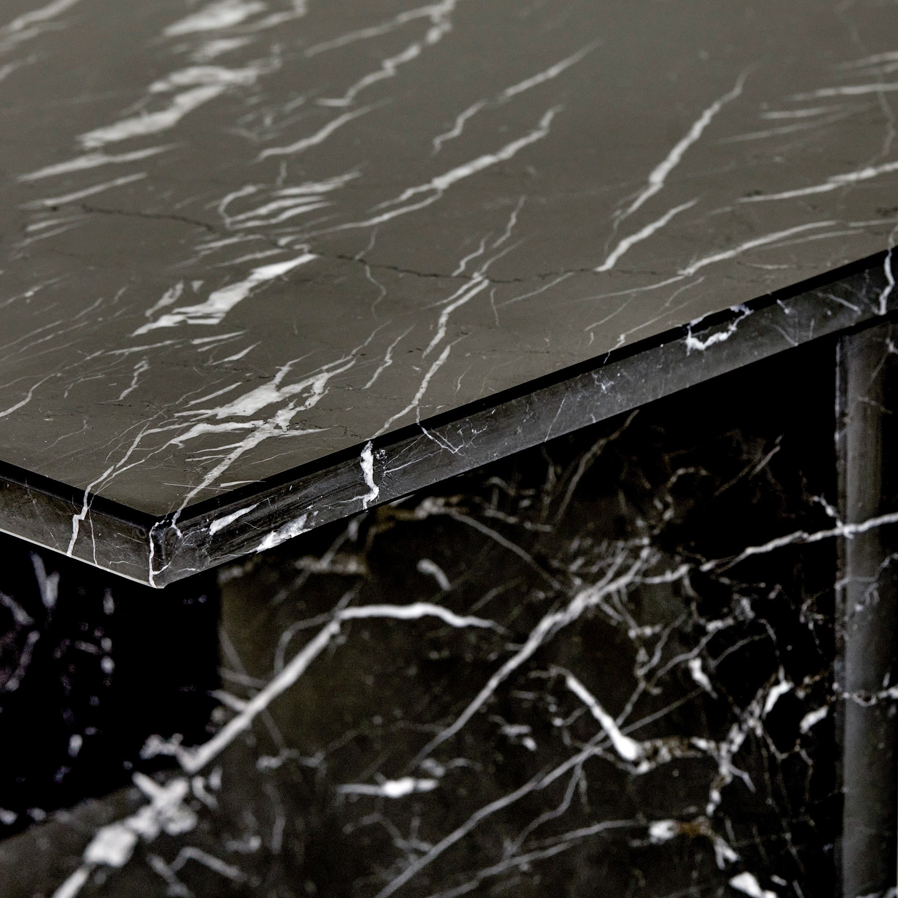 A close-up detail of a Gianna side table made from Nero Marquina marble.