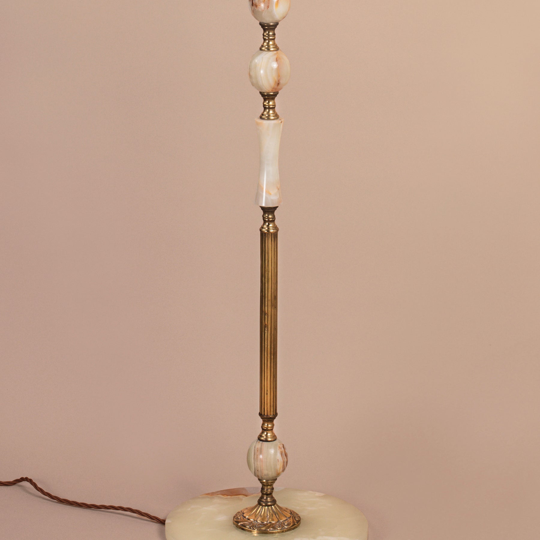 A close-up of a mid-century onyx and antique brass floor lamp.