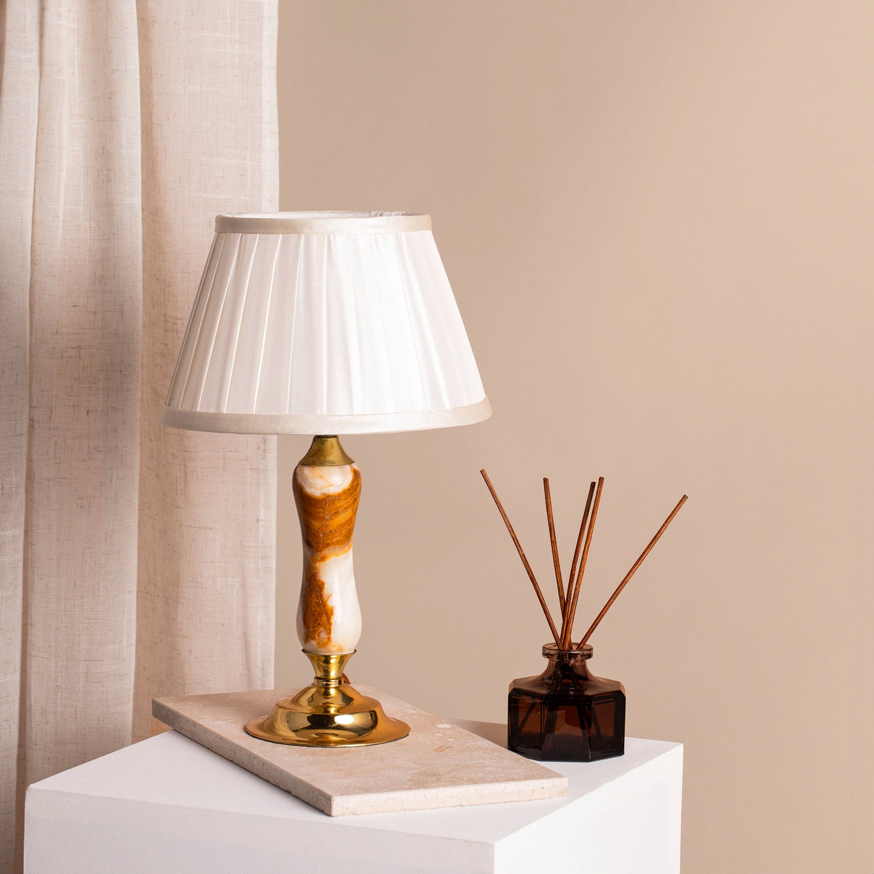 Mid-century white and red onyx table lamp with polished brass fittings on marble coaster and plinth.