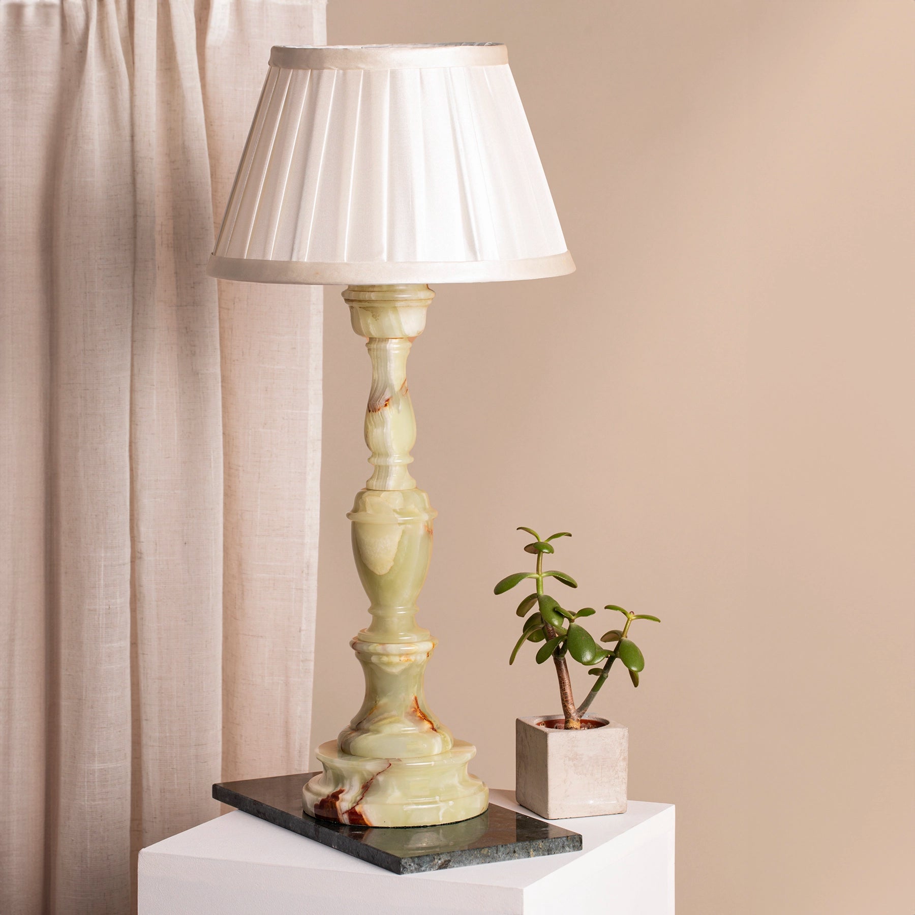 Vintage pale green onyx table lamp on marble coaster and plinth.