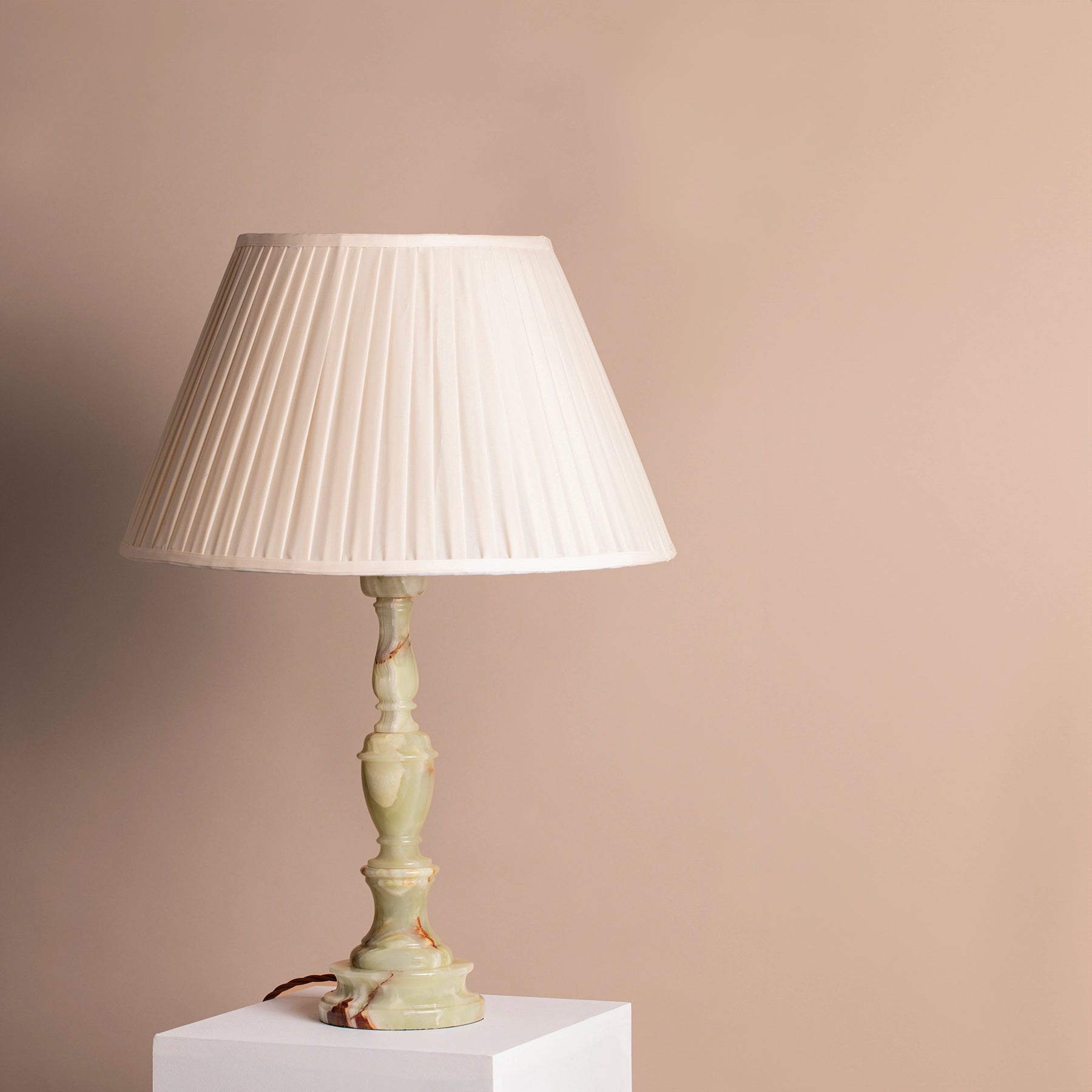 Vintage pale green onyx with red flecks table lamp on a plinth.