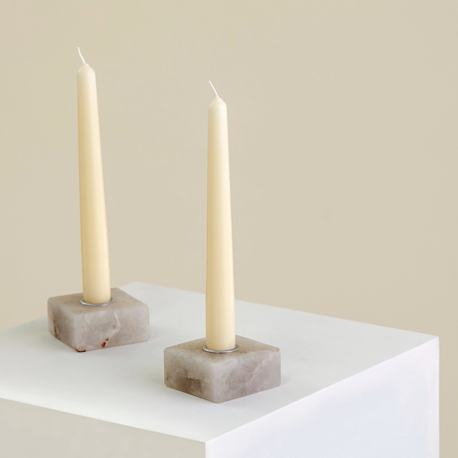 Two candle holders on a plinth made from Cristallo Imperial Onyx with silver detailing.