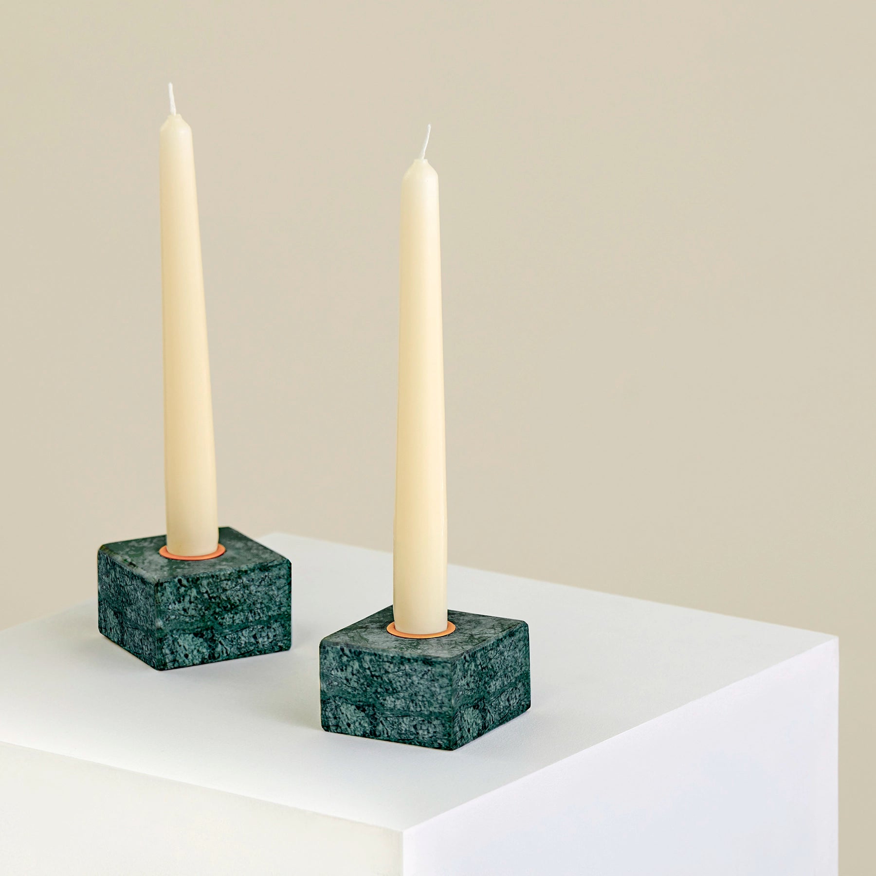 Two candle holders on a plinth made from Verde Guatemala marble with brass detailing.