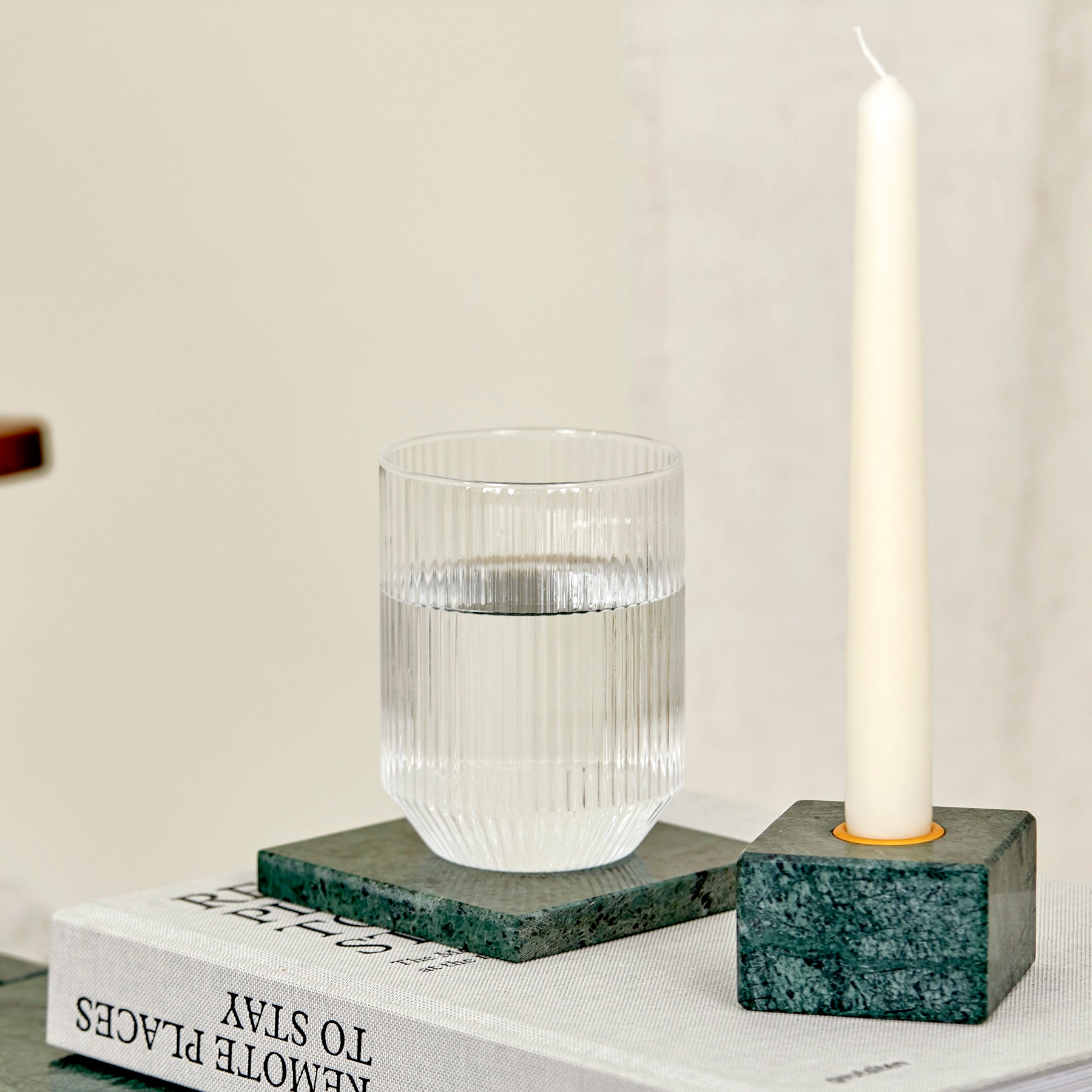 A close-up of candle holder and coaster made from Verde Guatemala marble.