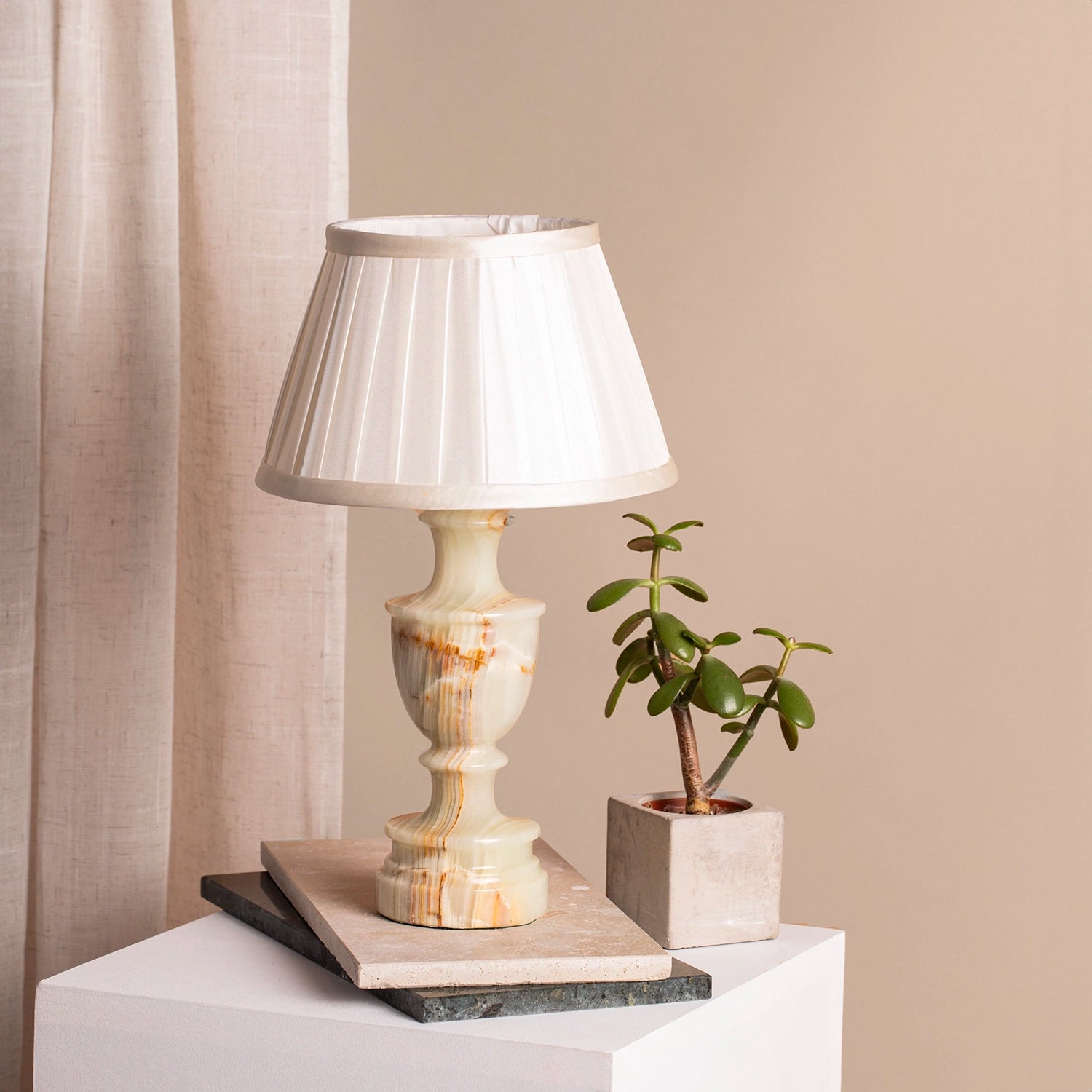 Vintage white alabaster with red flecks, table lamp on marble coasters and a white plinth.