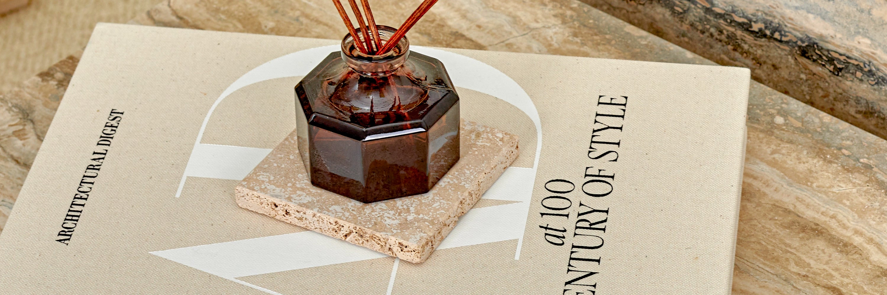 A close-up detail of an accessory on a Travertine marble coaster.