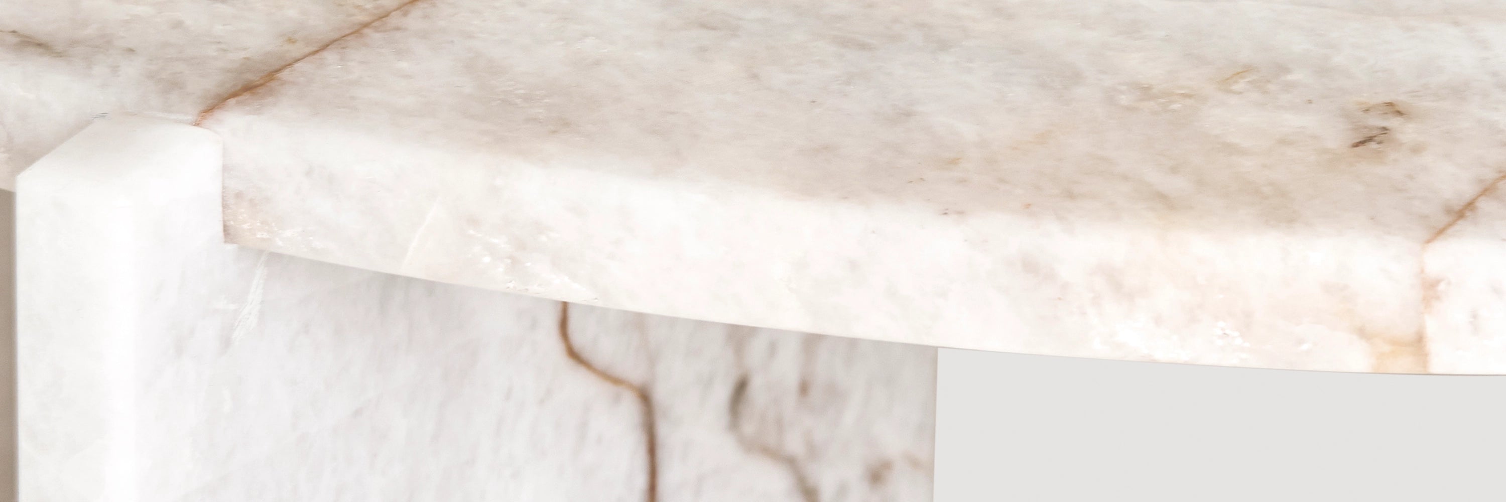 A close-up detail of a Minerva round side table made from Cristallo Imperial marble.