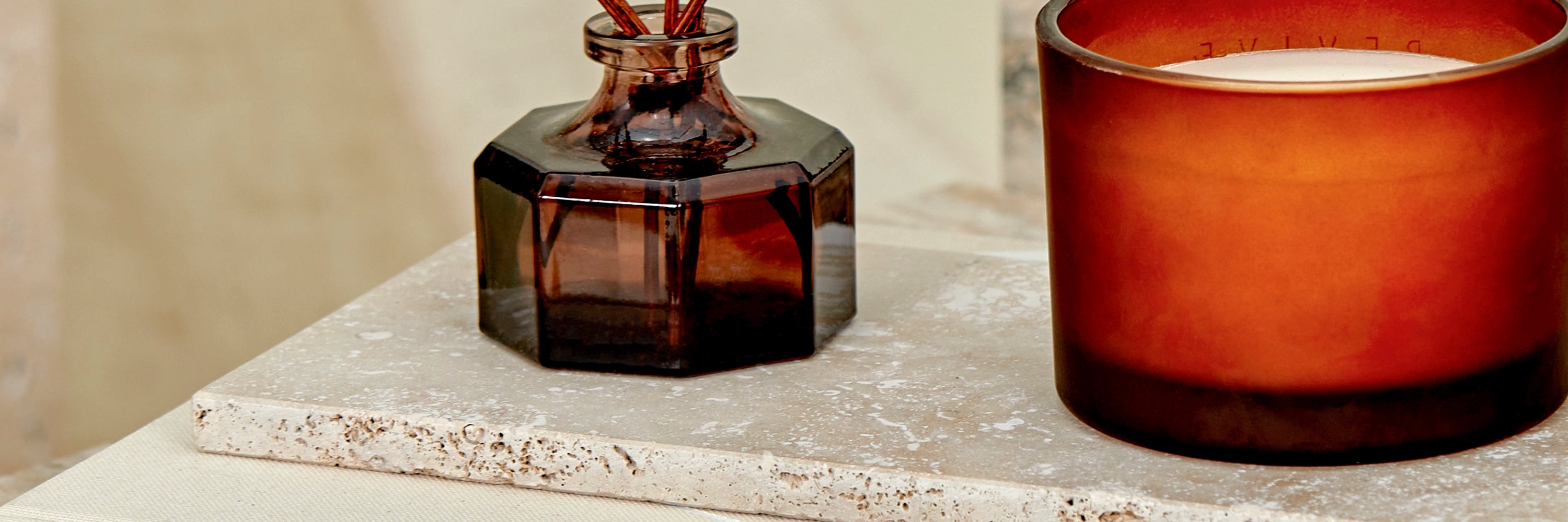 A close-up detail of accessories on a Travertine marble tray. 