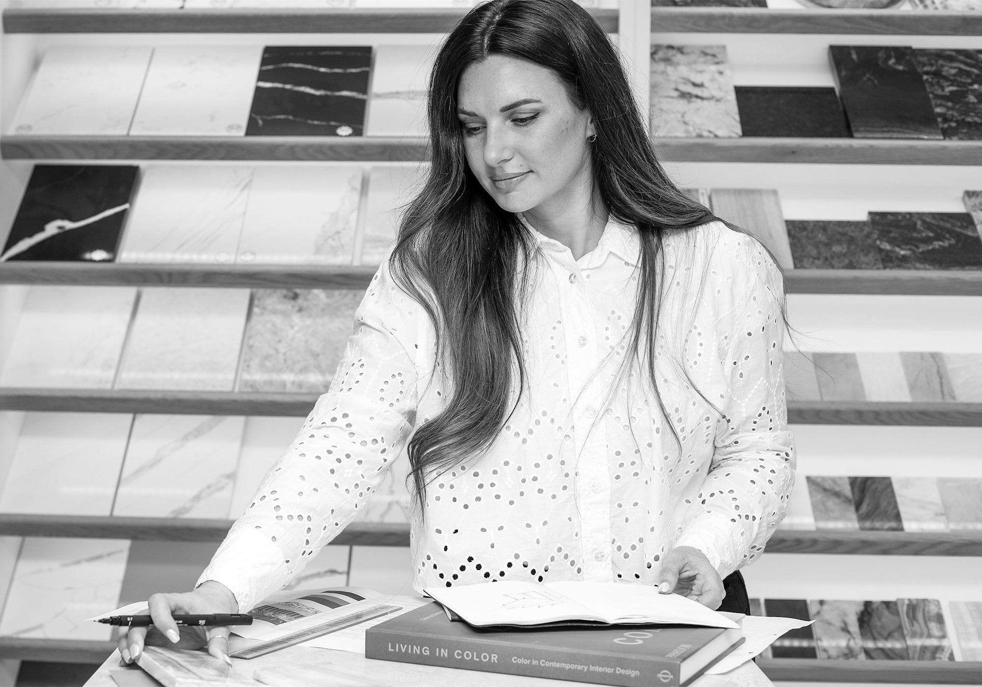 A black and white image of Francesca Haywood, founder of Marmo Lusso, working in the showroom.